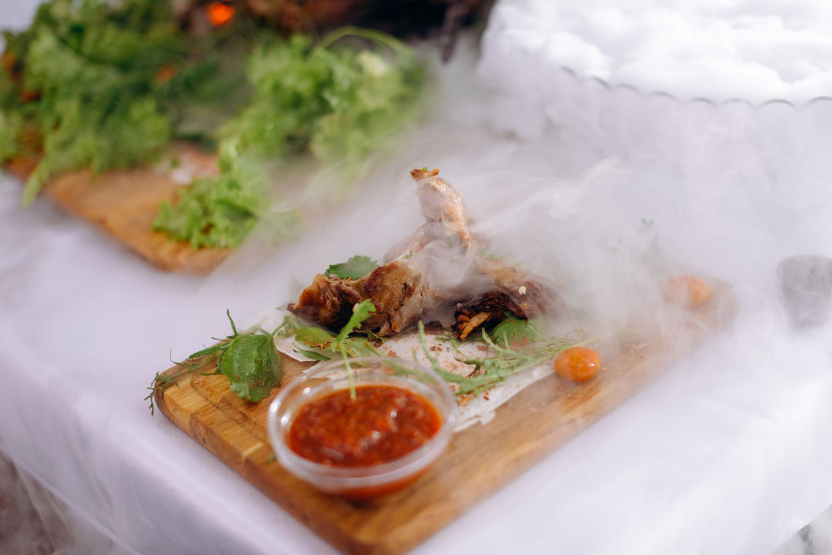 A gourmet meal featuring smoked chicken, fresh lettuce, and tangy sauce on a wooden board.