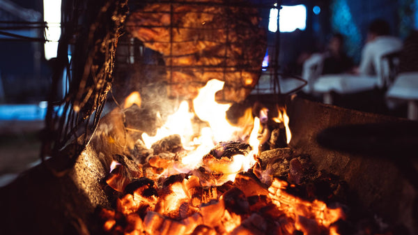 Juicy meat grilling over open flames in a barbecue pit, perfect for outdoor cooking scenes.