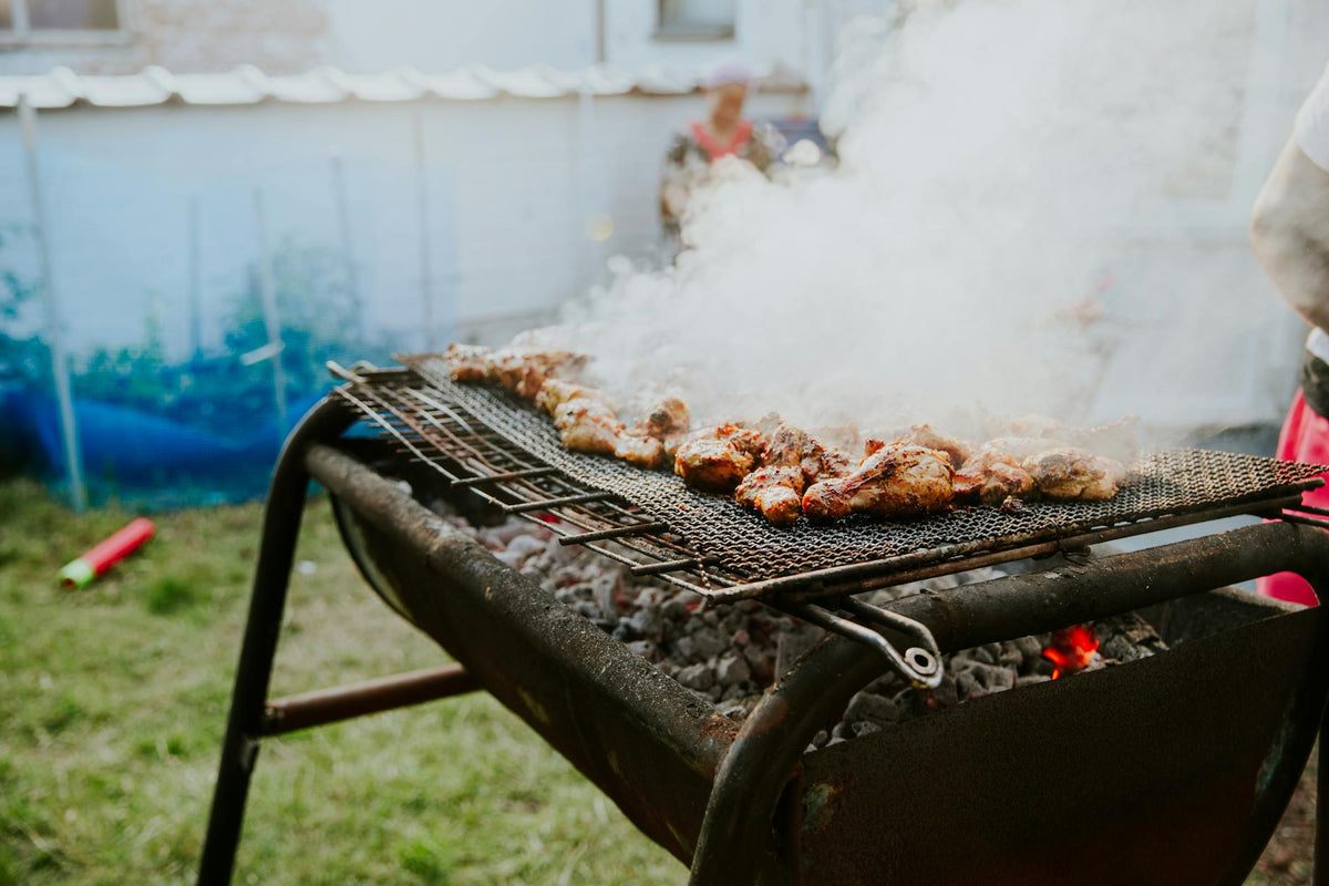 Succulent chicken wings grilling on a smoky outdoor barbecue grill.