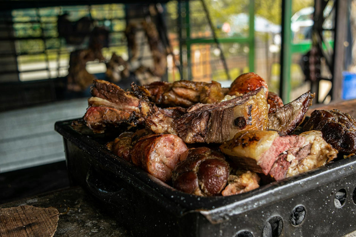 Delicious barbecue ribs and sausages on grill at outdoor picnic setting, capturing the essence of summer.