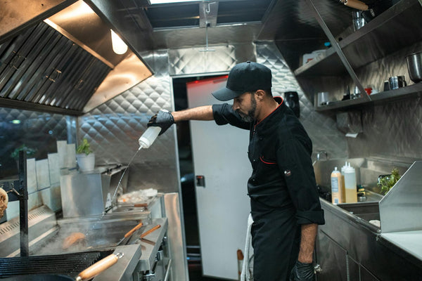 Chef preparing food in a modern industrial kitchen, showcasing culinary skills and food preparation.